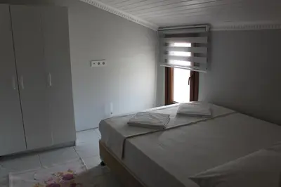 a white bedroom with a bed and a window at yelken apart hotel in Tekirdag