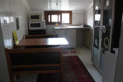 a small kitchen with a table and a refrigerator at yelken apart hotel in Tekirdag