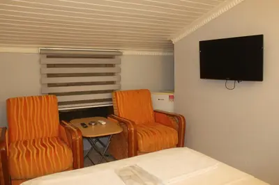a room with two chairs and a flat screen tv at yelken apart hotel in Tekirdag