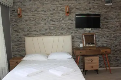 a bedroom with a bed and a tv on a brick wall at yelken apart hotel in Tekirdag