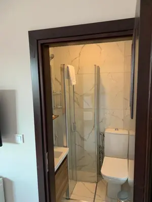 a bathroom with a toilet and a glass shower at Royal Residence Bursa in Bursa