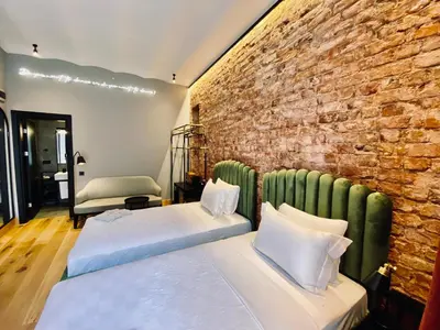 two beds in a room with a brick wall at RUZ Hotels in Istanbul