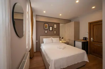 a bedroom with a white bed and a mirror at TAKSİM SUİTE in Istanbul