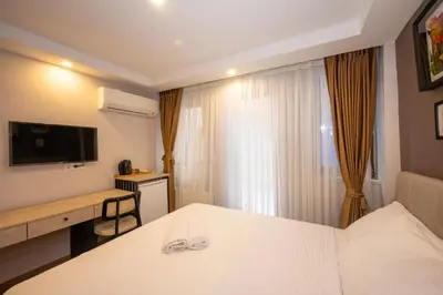a hotel room with a white bed and a television at TAKSİM SUİTE in Istanbul