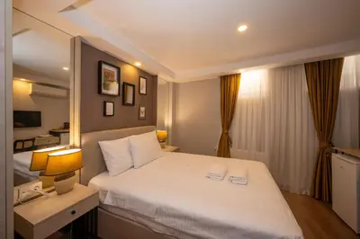 a bedroom with a large white bed and a desk at TAKSİM SUİTE in Istanbul