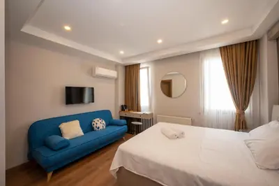 a bedroom with a bed and a blue couch at TAKSİM SUİTE in Istanbul