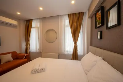 a bedroom with a white bed and a couch at TAKSİM SUİTE in Istanbul