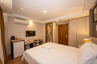 a hotel room with a white bed and a desk at TAKSİM SUİTE in Istanbul