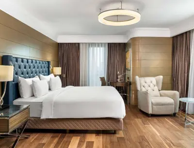 a bedroom with a large white bed and a chair at Radisson Blu Hotel, Istanbul Sisli in Istanbul