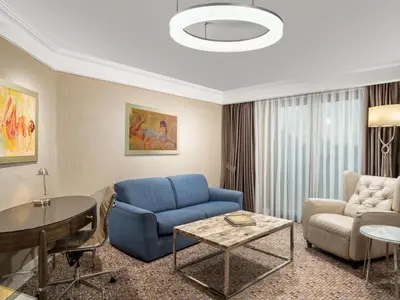 a living room with a blue chair and a couch at Radisson Blu Hotel, Istanbul Sisli in Istanbul
