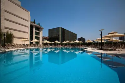 a large swimming pool with umbrellas and chairs at Radisson Blu Hotel, Istanbul Sisli in Istanbul