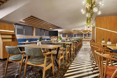a restaurant with tables and chairs in a room at Ramada Encore by Wyndham Istanbul Avcilar in Istanbul