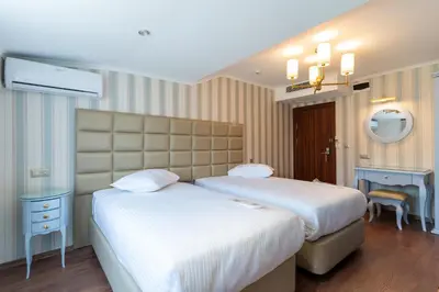 a hotel room with two beds and a mirror at Motali Life Hotel in Masukiye