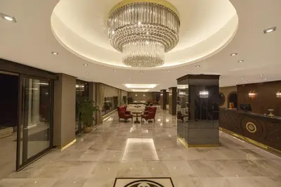 a lobby with a chandelier and a table and chairs at Motali Life Hotel in Masukiye