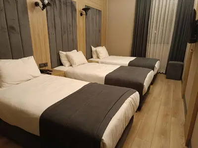 a hotel room with three beds in a room at Mineo Hotel Taksim in Istanbul
