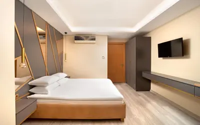a hotel room with a bed and a flat screen tv at Family Time Suites Hotel in Istanbul