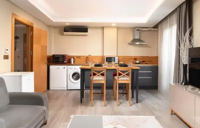 a kitchen and living room with a table and chairs at Family Time Suites Hotel in Istanbul