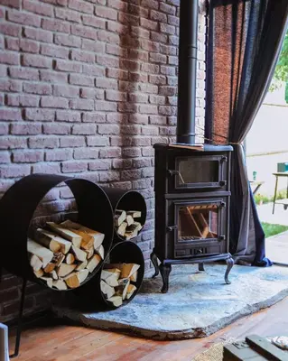 a wood stove in a room with a brick wall at Minimalist Sapanca in Sapanca