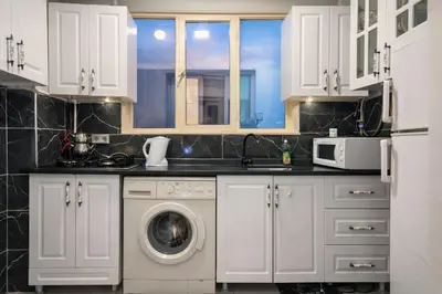 a kitchen with white cabinets and a washing machine at Alpacino Apart Hotel in Istanbul