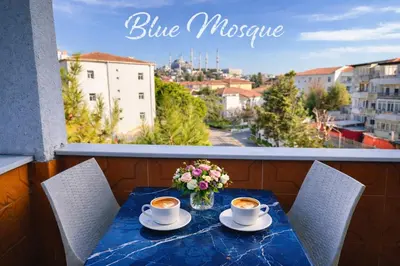 a table with two cups of coffee and flowers on a balcony at Alpacino Apart Hotel in Istanbul
