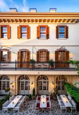 a hotel with tables and chairs in front of a building at Ecole St. Pierre Hotel in Istanbul