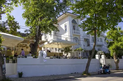 a white building with a restaurant in front of it at Ikigai Hotel Villa Rıfat in Adalar