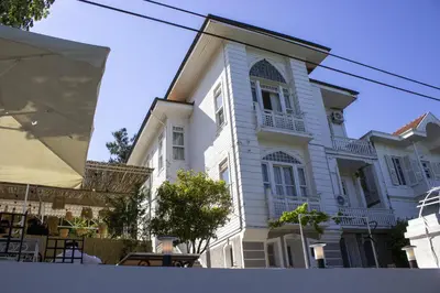 a large white house with a table in front of it at Ikigai Hotel Villa Rıfat in Adalar