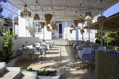 a restaurant with tables and chairs and chandeliers at Ikigai Hotel Villa Rıfat in Adalar