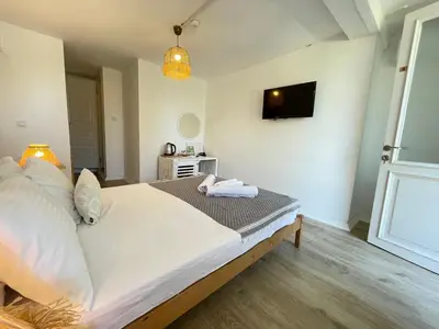a bedroom with a bed and a tv on the wall at Ikigai Hotel Villa Rıfat in Adalar