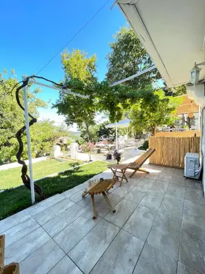 a patio with a bench and an umbrella at Ikigai Hotel Villa Rıfat in Adalar