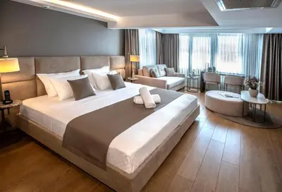 a bedroom with a large bed and a living room at Valente Suites&Hotel in Istanbul