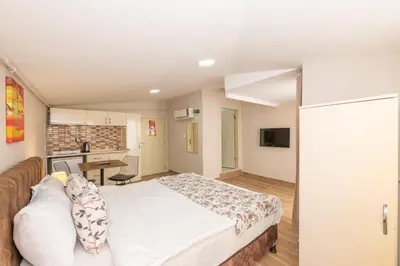 a bedroom with a white bed and a kitchen at Marida Residence - Istanbul Taksim in Istanbul