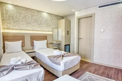 a room with two beds and a mirror at Florina Hotel in Istanbul