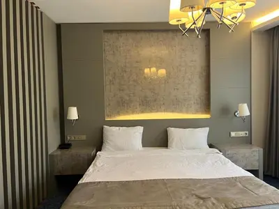 a bedroom with a large bed and a chandelier at Acar Suite Hotel in Istanbul