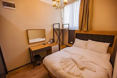 a bedroom with a bed and a desk with a mirror at Grand Balyan Hotel & Restaurant in Istanbul