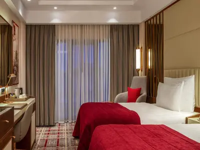 a hotel room with a bed with a red blanket at Mövenpick Hotel Istanbul Asia Airport in Istanbul