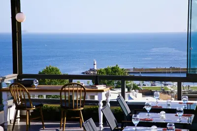a balcony with tables and chairs and a view of the ocean at HOTEL BRONTE in Istanbul