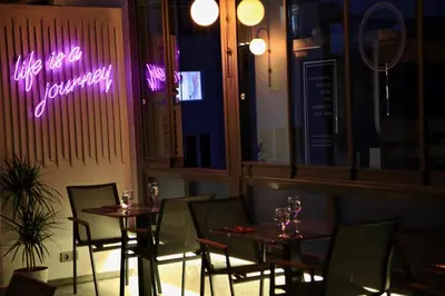 a restaurant with two tables and a neon sign at HOTEL BRONTE in Istanbul