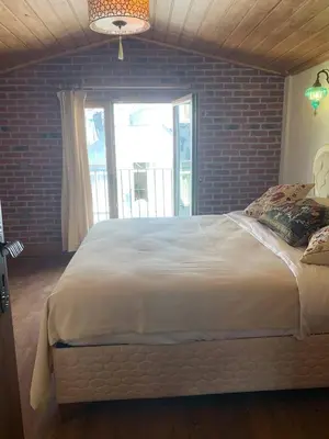 a large bed in a bedroom with a brick wall at Sofia Konaklama in Istanbul