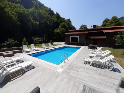 a swimming pool with lounge chairs next to a house at Feel & Live Hotel Villas Restaurant Sapanca in Sakarya