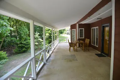 a screened porch of a house with a table and chairs at Feel & Live Hotel Villas Restaurant Sapanca in Sakarya