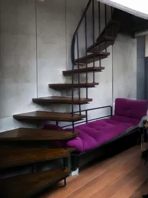a purple couch sitting under a staircase in a room at Mimoza İstiklal Apart Hotel in Istanbul
