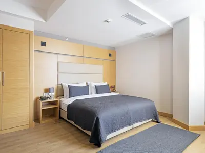 a bedroom with a large bed with blue pillows at Merlin Hotel İstanbul in Istanbul