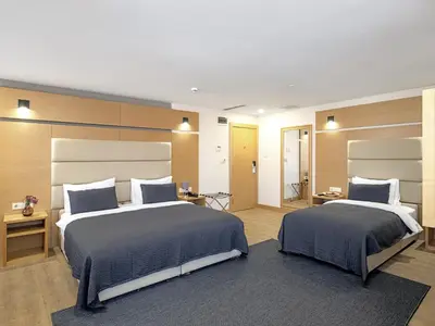 two beds in a hotel room with two beds sidx sidx sidx at Merlin Hotel İstanbul in Istanbul
