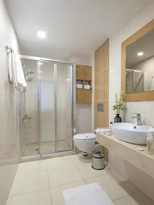a bathroom with a shower and a toilet and a sink at Merlin Hotel İstanbul in Istanbul