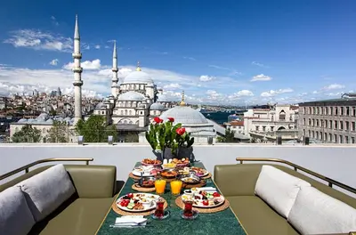 a table with food on a balcony with a view of a city at Mest Hotel Istanbul Sirkeci in Istanbul