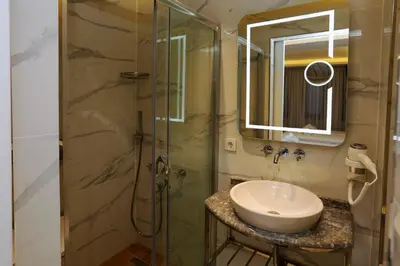 a bathroom with a sink and a glass shower at Sel Suite Hotel in Istanbul