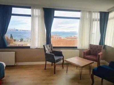 a room with two chairs and a table and windows at Cape Palace Hotel in Istanbul