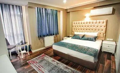 a bedroom with a large bed and a large window at Cape Palace Hotel in Istanbul