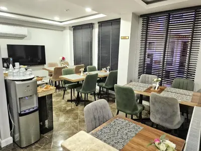 a restaurant with tables and chairs and a flat screen tv at Cape Palace Hotel in Istanbul